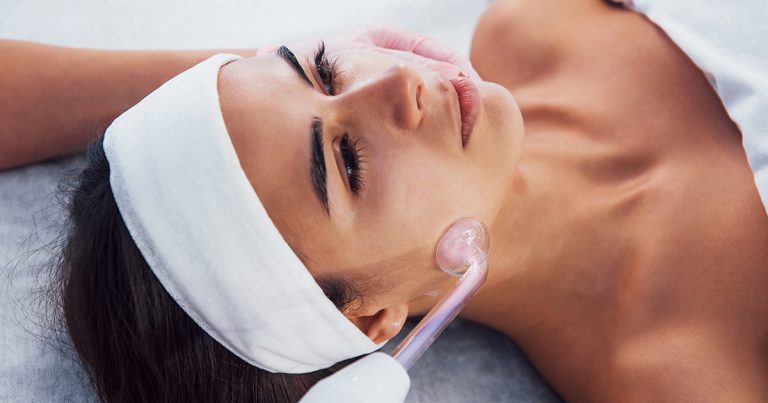 close up view of woman that lying down in spa salon and have face cleaning procedure by using modern device